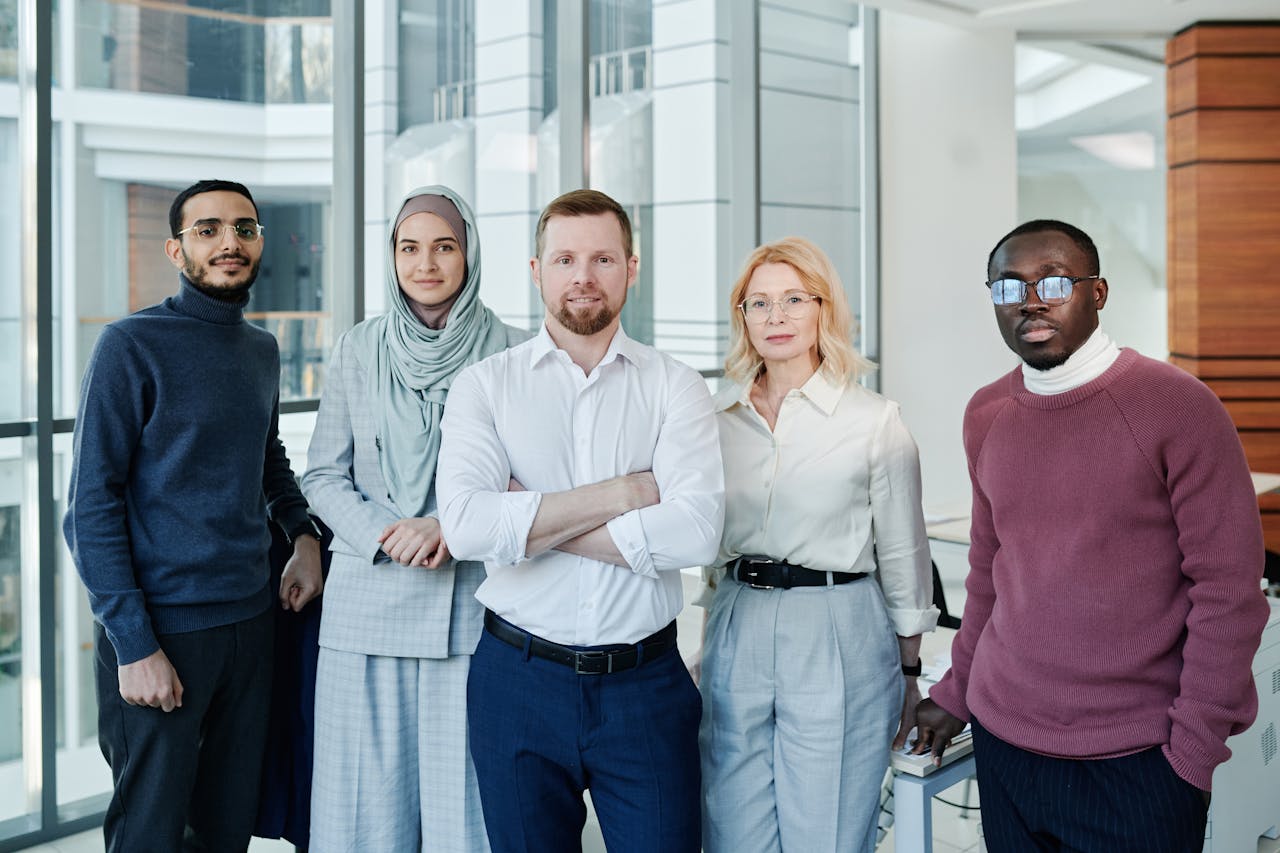 services-01 A diverse group of professionals posing confidently in a modern office environment.