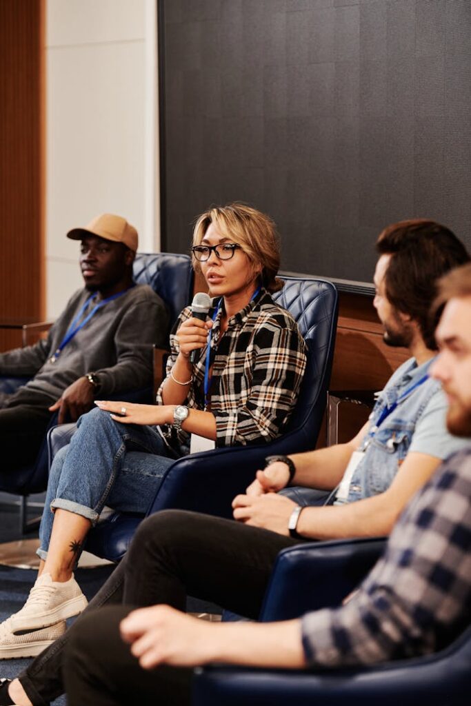 pexels photo 8344902 A diverse group of adults engaged in a panel discussion during a business seminar. Indoors setting.